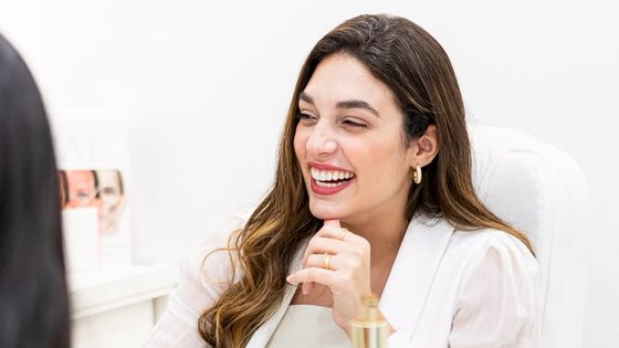 Dra. Luíse Ferrão durante uma consulta de avaliação, conversando com uma paciente.